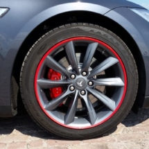 Close Up View Of Grey Tesla Model S Silver Alloy Wheel With Red AlloyGator Wheel Protector & Red Callipers