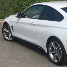 Side View Of White BMW With Silver Alloy Wheels, Gold AlloyGator Wheel Protection