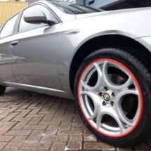Side View Of An Alfa Romeo With Silver Alloy Wheels And Red AlloyGator Rim Protectors