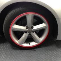 Close Up Of White Audi Alloy Wheel With Red AlloyGator Wheel Protector