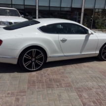 Close Up Side View Of White Bentley With Silver Alloy Wheels With Silver AlloyGator Wheel Rim Protector