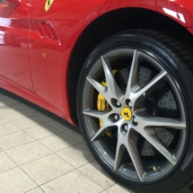 Close Up View Of Front Wheel Of A Red Ferrari With Silver Alloy Wheels, Black AlloyGator Alloy Wheel Rim Protector & Yellow Brake Callipers