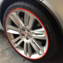 Close Up Of A Silver Jaguar Alloy Wheel With Red AlloyGator Alloy Wheel Protector